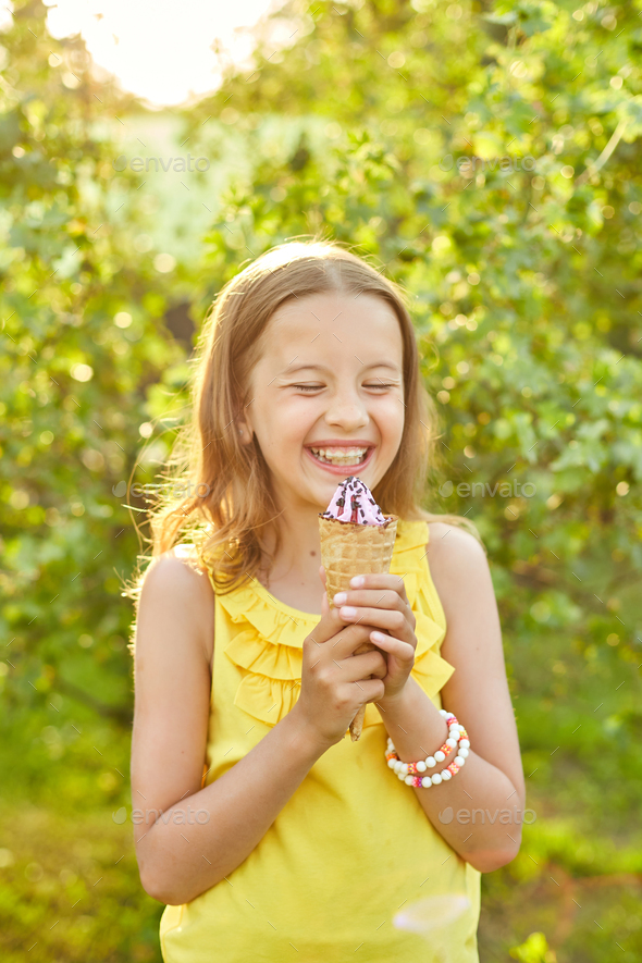 Happy girl with braces eating italian ice cream cone smiling while